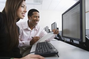 Man and woman using computer together